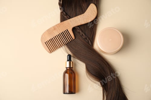 Preview: Hair lock, comb and cosmetic products on beige background, flat lay