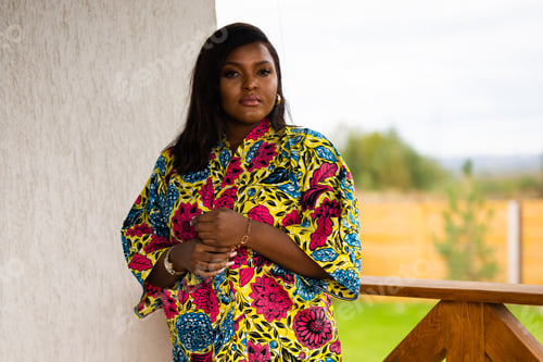 Preview: Beautiful african american woman enjoying evening on village and nature on terrace of country house