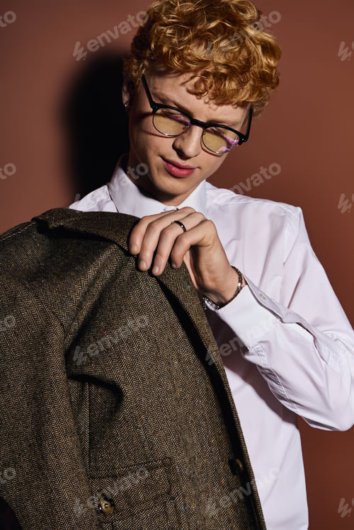 Preview: Stylish young man adjusting his fashionable jacket in a modern setting