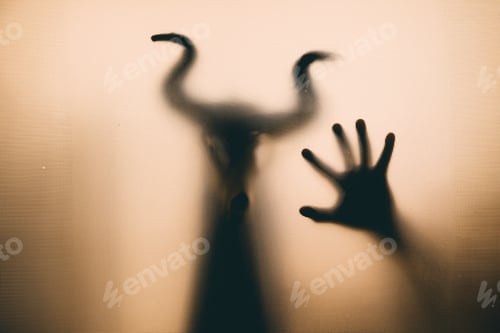 Preview: Horror, halloween background - Shadowy figure with horns behind the glass