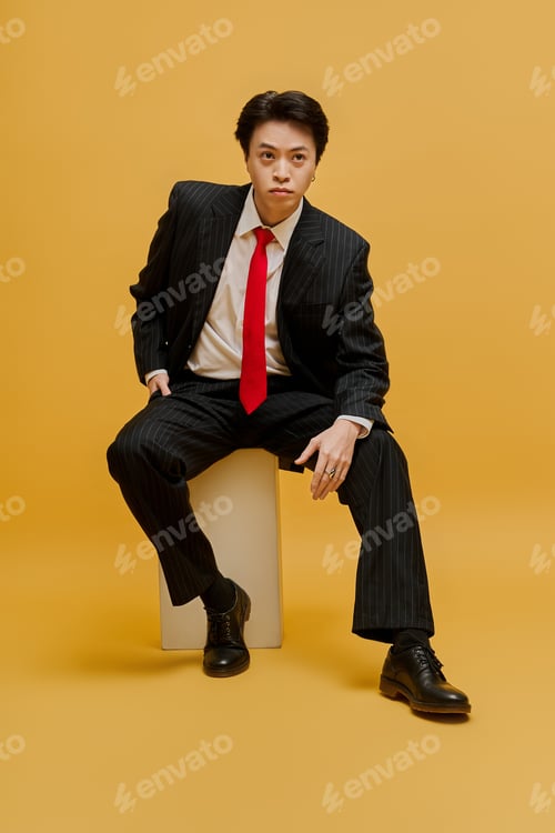 Preview: Elegant young businessman showcasing fashion in a vibrant studio setting