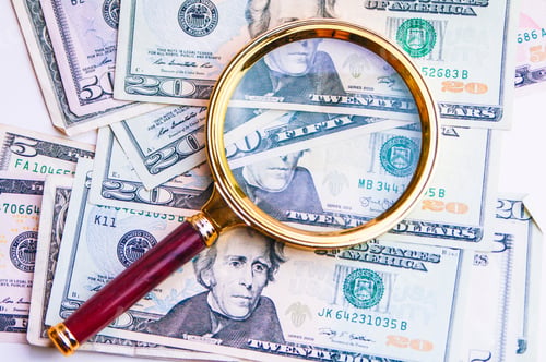 Preview: the magnifying glass is on top of a wad of dollars