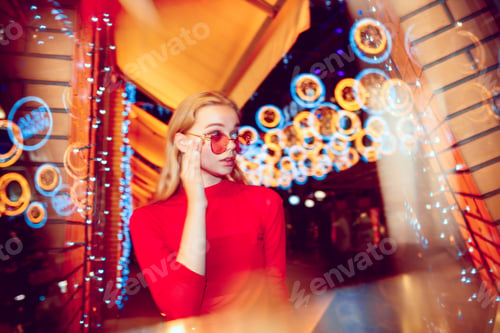 Preview: Cinematic portrait of handsome young woman in neon lighted room, stylish musician