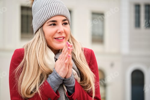 Preview: Caucasian young blonde woman rubbing her hands during winter.