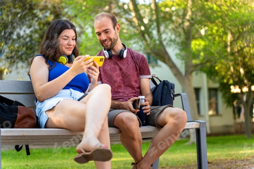 Preview: College students looking at phone and laughing together during class break