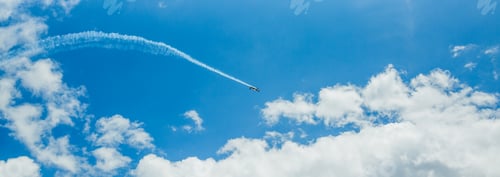 Preview: Single one sport plane of aerobatic team vapour trails in blue sky. Plane white vapour trails tracks