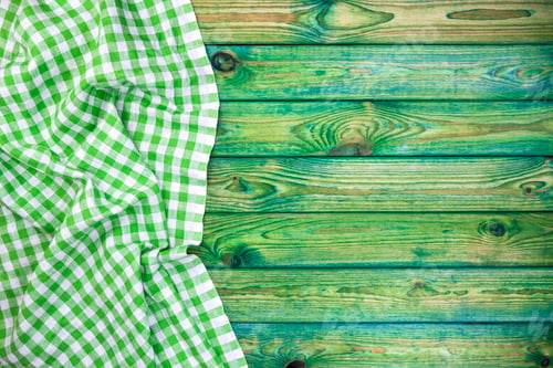 Preview: Green checkered tablecloth on wooden table, top view, copy space