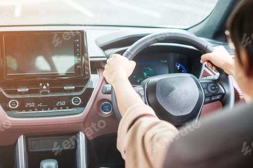 Preview: woman driver driving a car on the road, hand controlling steering wheel