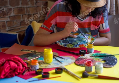 Preview: A woman painting on the table, colorful painting tools, palette and Coca-Cola bottles on the table