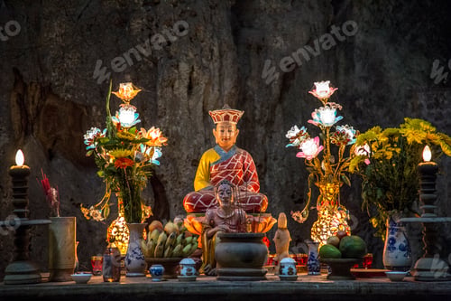 Preview: Buddha decorated with candles and flowers inside the pagoda of the Marble Mountains