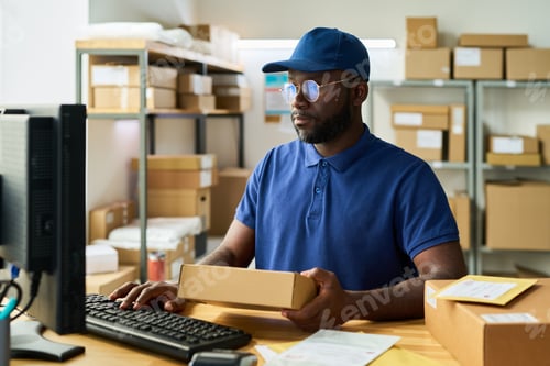 Preview: Young Adult Black Man Processing Online Orders in Warehouse Office Setting