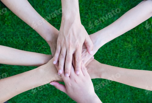 Preview: Close up asian business people hands together over green grass out of office,Teamwork concept