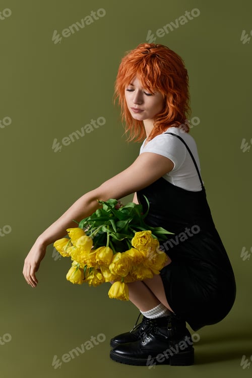 Preview: Stylish woman displays spring fashion with bright yellow flowers on green