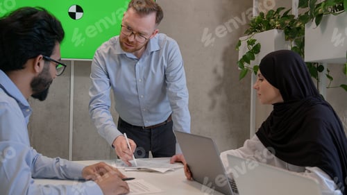 Preview: Multiethnic colleagues businessmen and muslim businesswoman in hijab teamwork in office boardroom