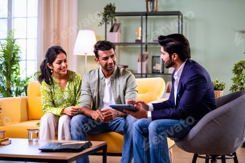 Preview: Indian family investment consultation at home with professional agent reviewing paperwork
