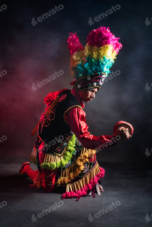 Preview: Matlachines Dancer from Coahuila Mexico A man in a colorful costume is kneeling on the ground