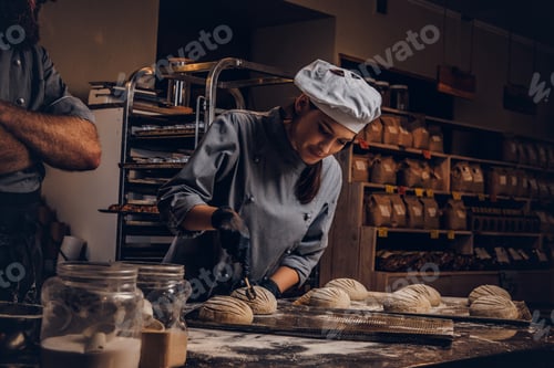 Preview: Chef teaching his assistant to bake the bread in a bakery.