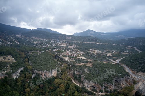 Preview: Aerial view of beautiful mountain valley with forest and village.