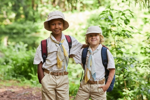 Preview: Two cute boy scouts looking at camera outdoors in forest enjoying field trip