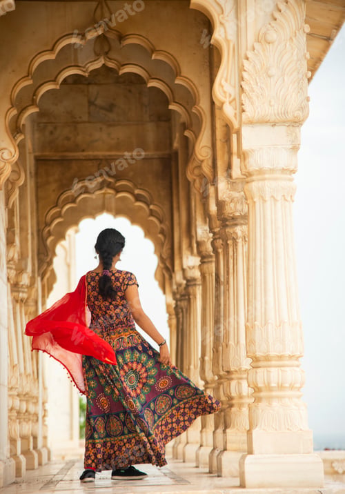Preview: Young female tourist dancing between arches and Pillars.