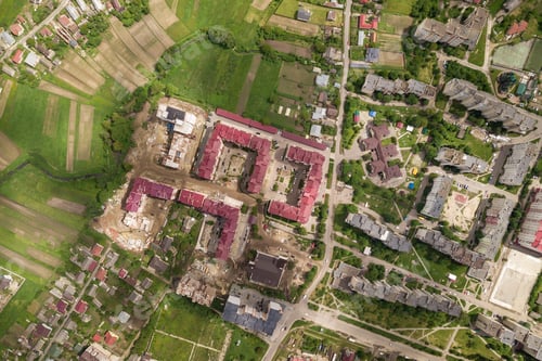 Preview: Aerial view of town or city with rows of buildings and curvy streets in summer. Urban landscape from
