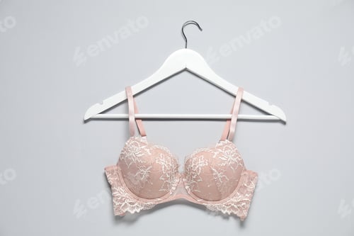 Preview: Hanger with beautiful lace bra on light background, top view