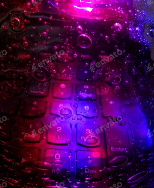 Preview: Visualizing data & cyber security concept with neon lights reflected on computer’s keyboard