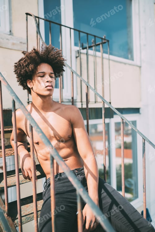 Preview: shirtless young black man sitting in the stairs