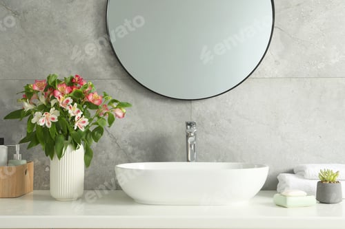 Preview: Vase with beautiful Alstroemeria flowers and toiletries near sink in bathroom