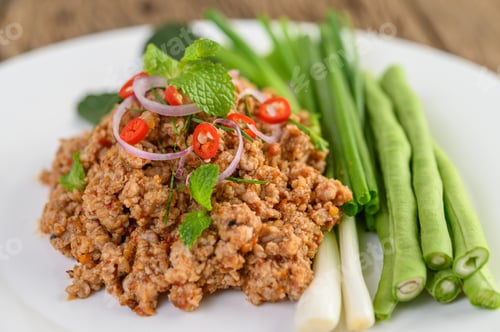 Preview: Spicy Minced Pork Salad on a white plate with lentils, kaffir lime leaves and spring onions.