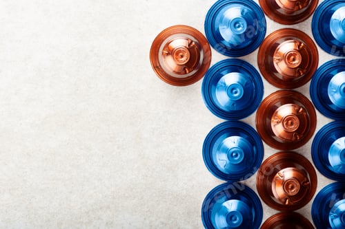 Preview: Espresso coffee capsules or pods and coffee beans on grey background