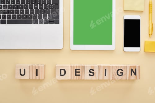 Preview: flat lay with gadgets and wooden blocks with ui design lettering on yellow background