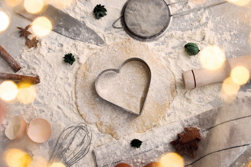 Preview: Flat lay composition with heart shaped cookie cutter, dough and ingredients on table