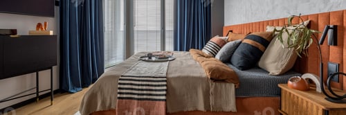 Preview: Warm and cozy bedroom interior with big orange bed and personal accessories. Home decor. Template.