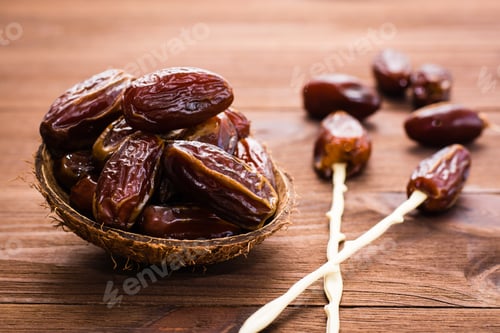 Preview: Dried sweet dates fruit in the bowl, chopsticks for eating on wooden background