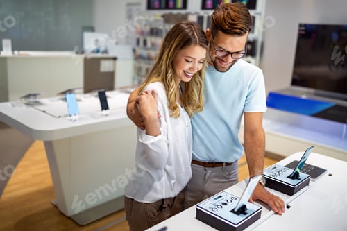Preview: Tech shopping device gadget concept. Happy young people buying a new smartphone in mobile shop.