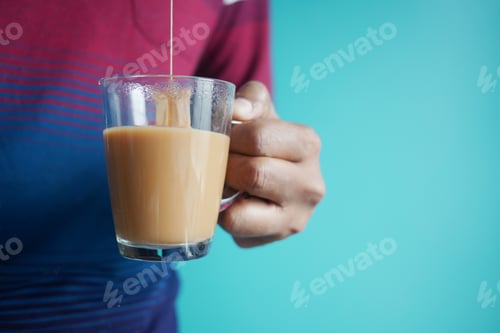 Preview: hand pouring a tea bag into a tea cup