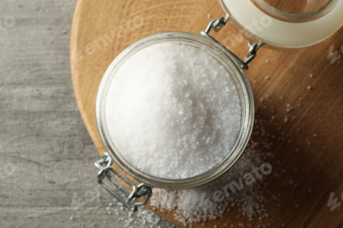 Preview: Board with glass jar of salt on gray table