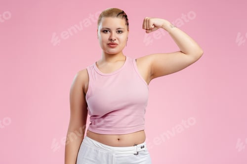 Preview: Young woman showing her bicep on pink background