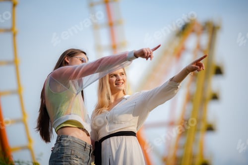 Preview: young woman having fun and happy smiling together at amusement theme park outdoor