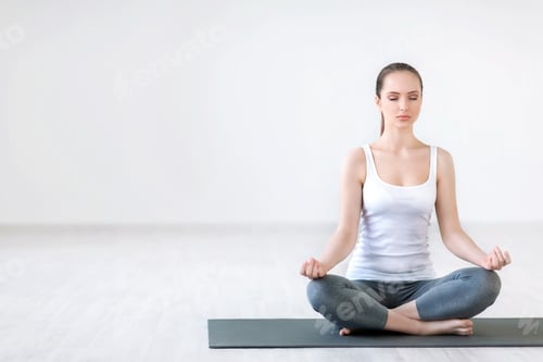 Woman Meditating in Lotus Position on Yoga Mat