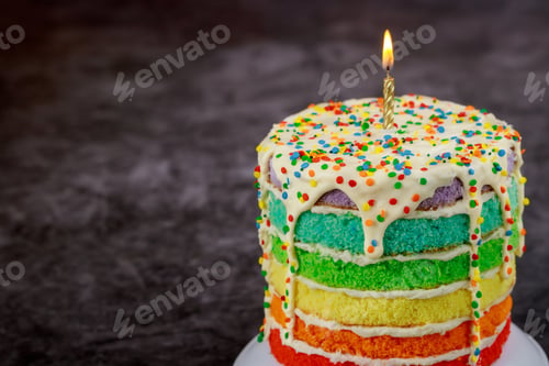 Preview: Birthday cake with burning candle and sprinkles.