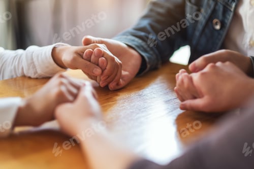 Preview: Group of people sitting in a circle holding hands and pray together or in therapy session