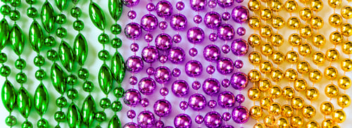 Preview: Mardi Gras background. Multi-colored beads close-up.