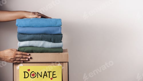 Preview: Clothes Donation, Renewable Concept.Hands folding and packing clothes into box at home