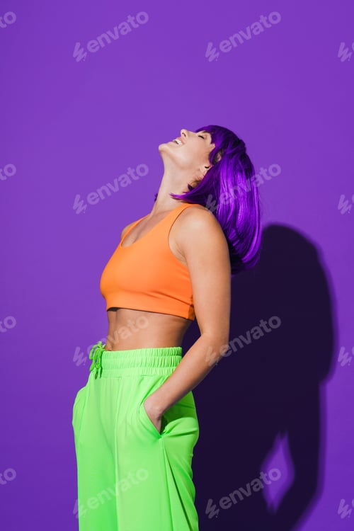 Preview: Young woman wearing colorful sportswear against purple background
