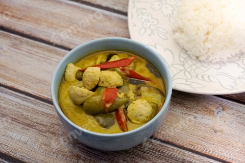 Preview: Green Curry With Fish Balls And Steamed Rice On A Wooden Table