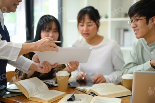 Preview: Senior professor explaining something to students during class at university