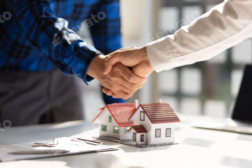 Preview: Real estate agents shake hands after the signing of the contract agreement is complete.
