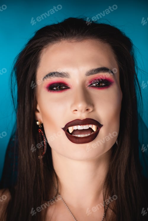 Preview: brunette vampire with black makeup and white scary teeth on blue